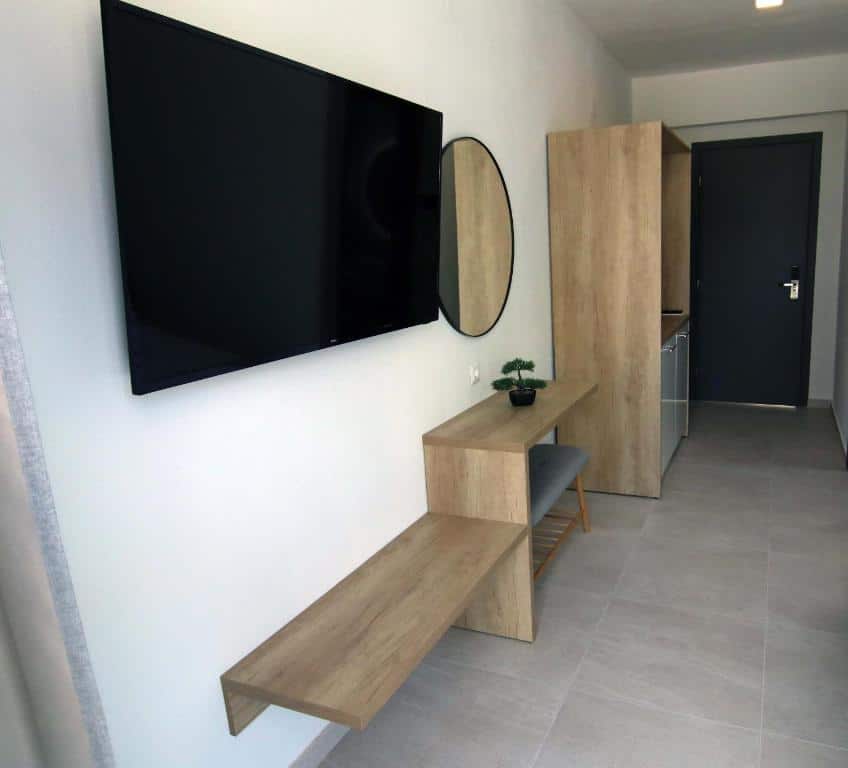 Room with one double bed, a tv and a chair