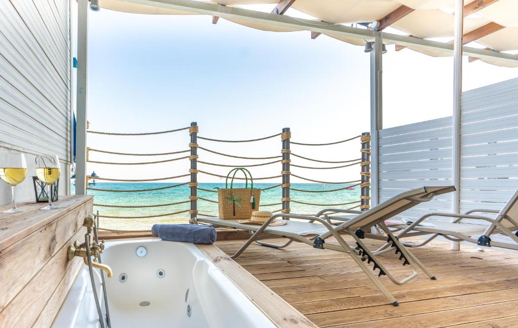 Bath tub and deck chair in front of the sea